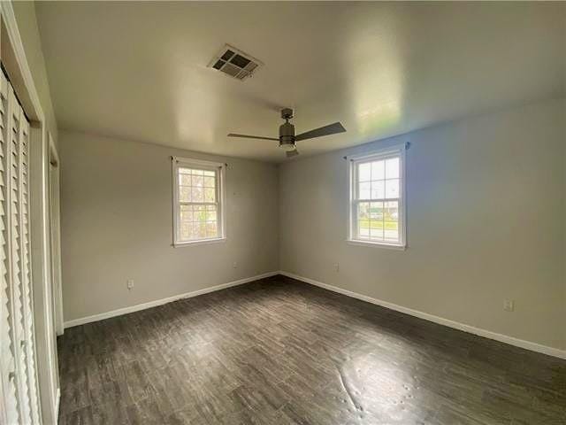 2359 Prentiss Ave, New Orleans, LA 70122 - unfurnished bedroom with dark wood-style flooring, visible vents, multiple windows, and baseboards
