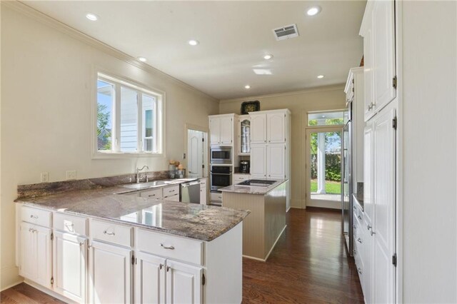 3752 Lake Charles Dr, Gretna, LA 70056 - kitchen with crown molding, dark wood finished floors, a peninsula, and stainless steel appliances