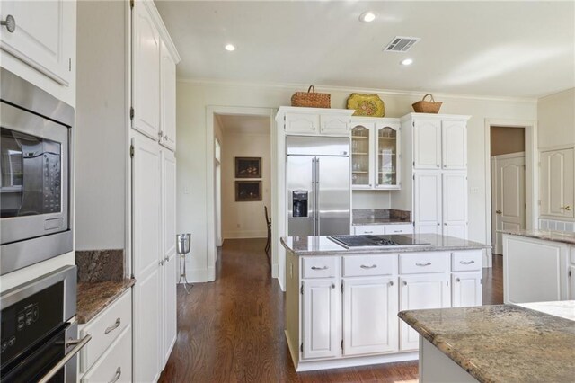 3752 Lake Charles Dr, Gretna, LA 70056 - kitchen featuring light stone countertops, white cabinets, visible vents, dark wood-style flooring, and built in appliances