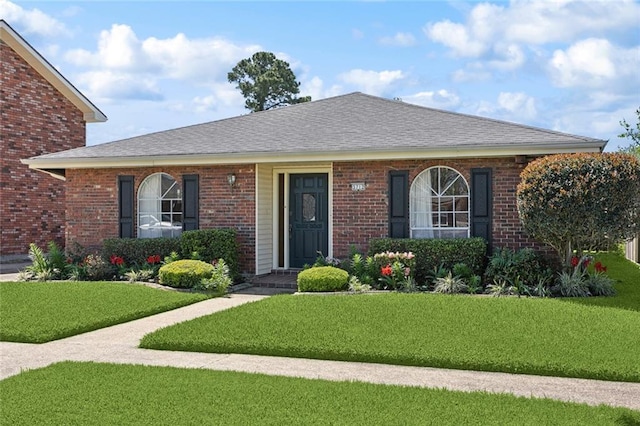 ranch-style house with brick siding, a shingled roof, and a front lawn