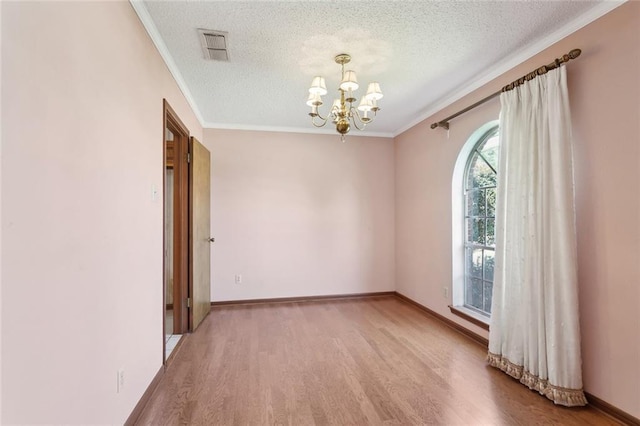 unfurnished room with crown molding, light wood-type flooring, a textured ceiling, and a notable chandelier