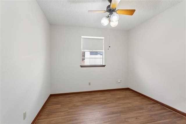 unfurnished room with baseboards, a textured ceiling, ceiling fan, and wood finished floors