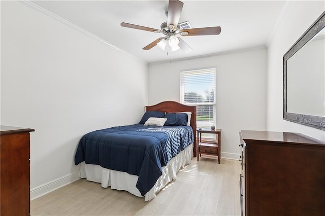 bedroom featuring a ceiling fan, baseboards, ornamental molding, and light wood-style flooring