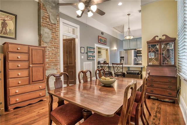 dining room featuring high vaulted ceiling, light wood-style floors, visible vents, and ceiling fan