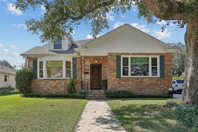 bungalow with brick siding and a front yard