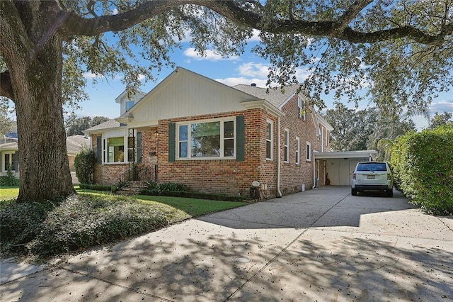 view of front of home featuring concrete driveway, brick siding, and a carport