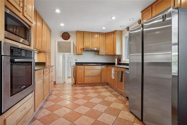 kitchen with dark countertops, light tile patterned flooring, stainless steel appliances, under cabinet range hood, and recessed lighting