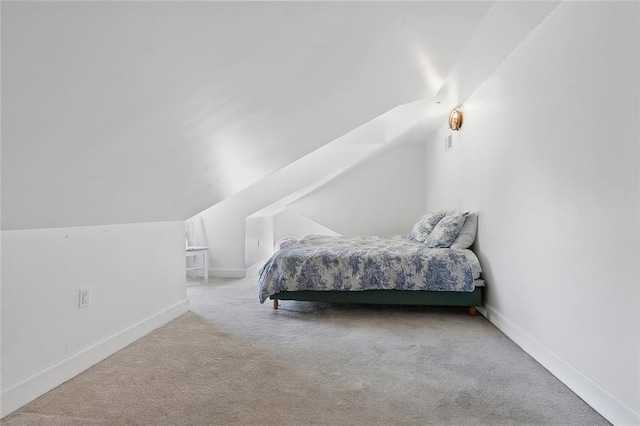 carpeted bedroom featuring vaulted ceiling and baseboards