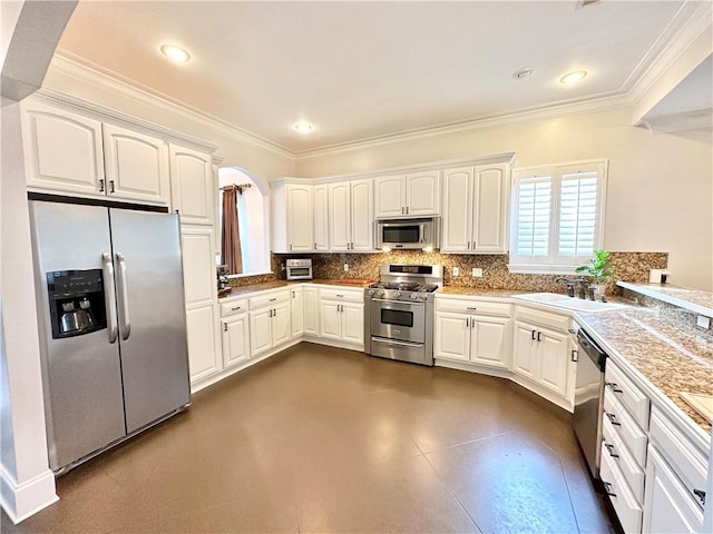 kitchen with decorative backsplash, ornamental molding, white cabinets, a sink, and appliances with stainless steel finishes
