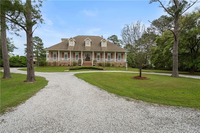 view of front facade featuring a front yard, curved driveway, and a porch