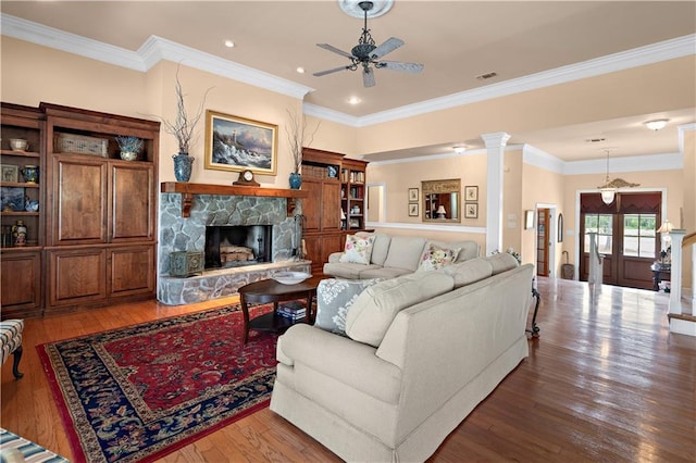 living room with crown molding, a fireplace, a ceiling fan, visible vents, and hardwood / wood-style floors