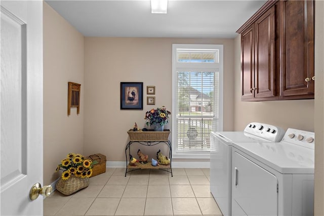 laundry room featuring cabinet space, light tile patterned floors, baseboards, and washer and dryer