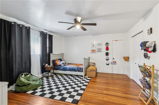 bedroom featuring wood-type flooring and a ceiling fan