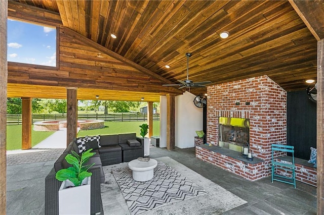 view of patio featuring an outdoor living space with a fireplace, fence, and ceiling fan
