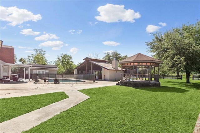 view of yard featuring a patio area, a gazebo, fence, and a fenced in pool