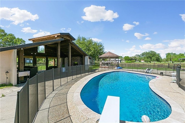 view of swimming pool with a gazebo, a fenced in pool, a patio, and a diving board