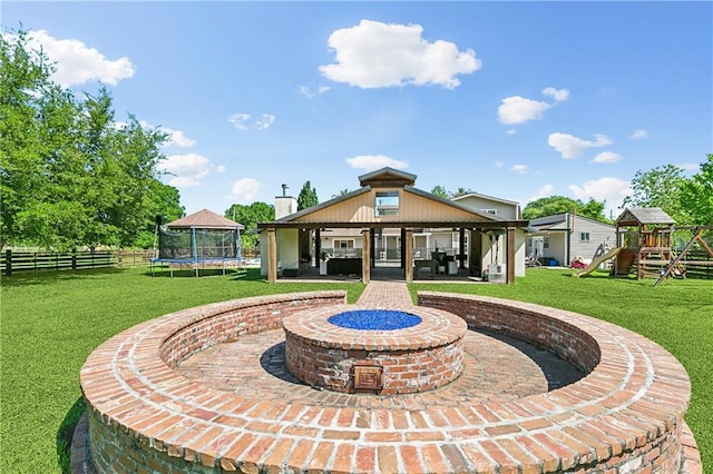 exterior space featuring a gazebo, a trampoline, a lawn, a playground, and fence