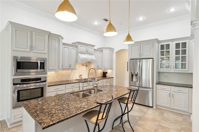 809 S Corniche Du Lac, Covington, LA 70433 - kitchen with stainless steel appliances, ornamental molding, a kitchen bar, arched walkways, and decorative backsplash