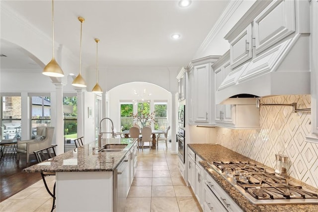 809 S Corniche Du Lac, Covington, LA 70433 - kitchen with appliances with stainless steel finishes, arched walkways, a kitchen bar, tasteful backsplash, and ornamental molding
