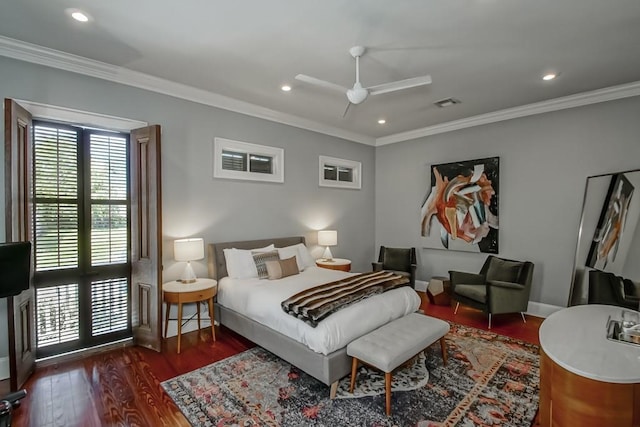 bedroom with crown molding, wood finished floors, baseboards, and visible vents