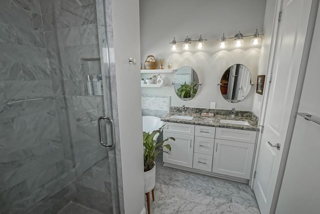 full bath with a stall shower, double vanity, marble finish floor, and a sink