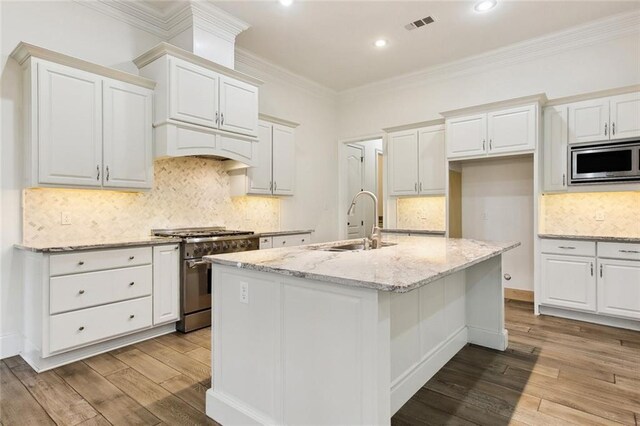 kitchen featuring white cabinets, light wood finished floors, a sink, and appliances with stainless steel finishes
