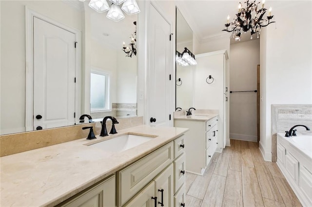 full bathroom with a chandelier, two vanities, a sink, and ornamental molding