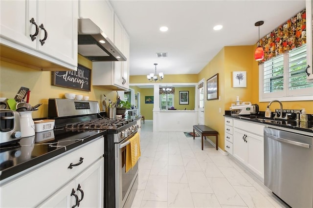 3000 Clifford Dr, Metairie, LA 70002 - kitchen with wall chimney range hood, marble finish floor, dark countertops, stainless steel appliances, and a notable chandelier