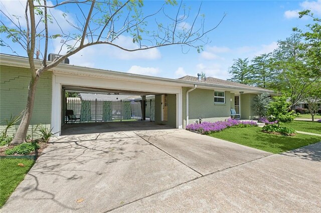 3000 Clifford Dr, Metairie, LA 70002 - view of side of property with brick siding, a lawn, an attached carport, and driveway