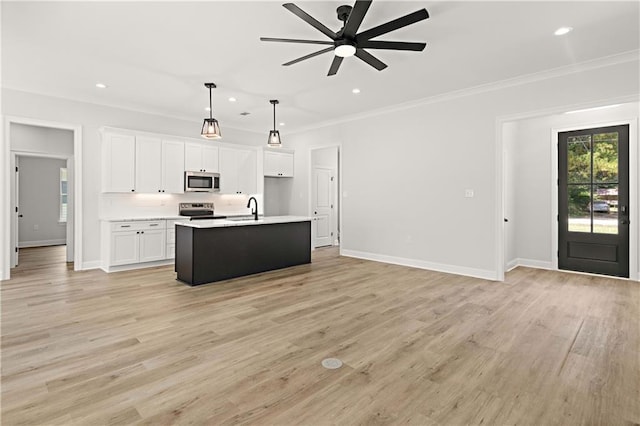 kitchen featuring appliances with stainless steel finishes, white cabinetry, crown molding, ceiling fan, and a sink