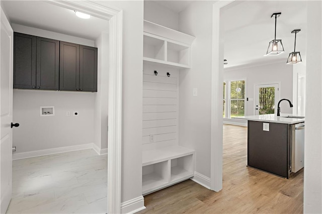 mudroom featuring marble finish floor, a sink, and baseboards