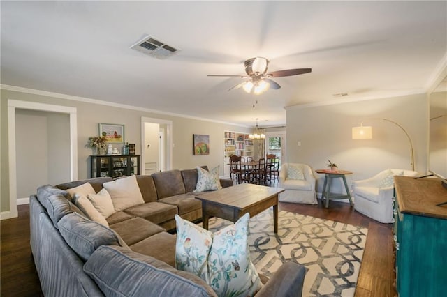 living area with ceiling fan, crown molding, wood finished floors, a chandelier, and baseboards