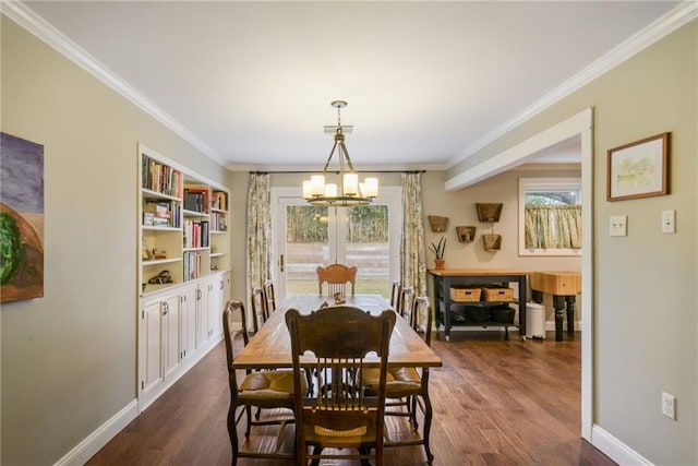 dining space with a chandelier, ornamental molding, dark wood finished floors, and baseboards