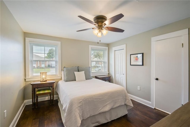 bedroom with multiple windows, baseboards, and dark wood-type flooring