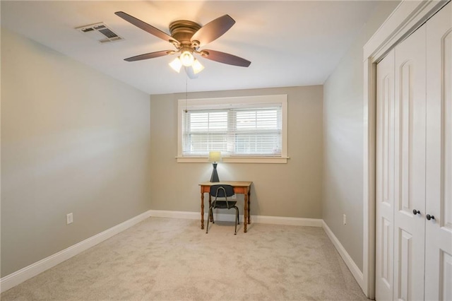 spare room with a ceiling fan, light carpet, and baseboards