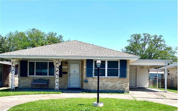 view of front facade with driveway, fence, a porch, and brick siding
