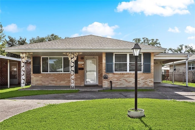 1017 Elmeer Ave, Metairie, LA 70005 - view of front facade featuring brick siding, asphalt driveway, and a carport