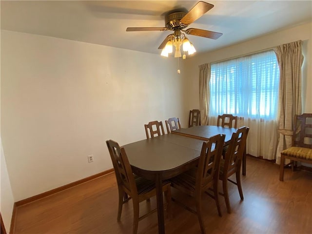 dining room with baseboards, ceiling fan, and light wood-style flooring