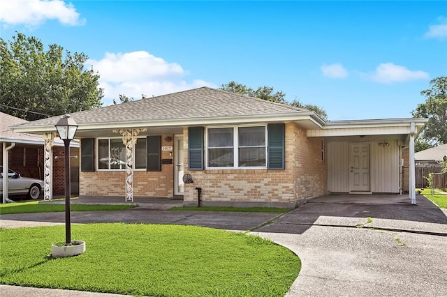 1017 Elmeer Ave, Metairie, LA 70005 - single story home featuring asphalt driveway, brick siding, a carport, and a shingled roof