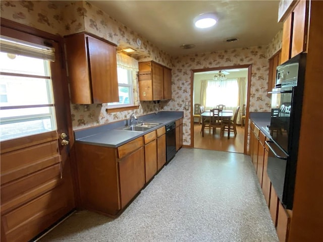 kitchen with brown cabinets, wallpapered walls, and a sink