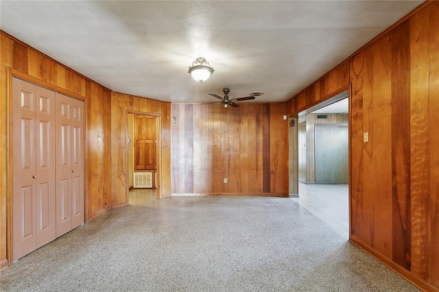 1017 Elmeer Ave, Metairie, LA 70005 - empty room with wooden walls, baseboards, ceiling fan, and speckle patterned floor