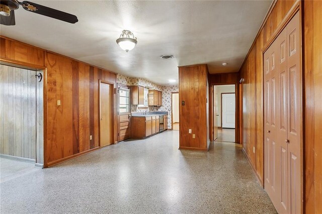 1017 Elmeer Ave, Metairie, LA 70005 - kitchen with brown cabinets, baseboards, ceiling fan, and wooden walls