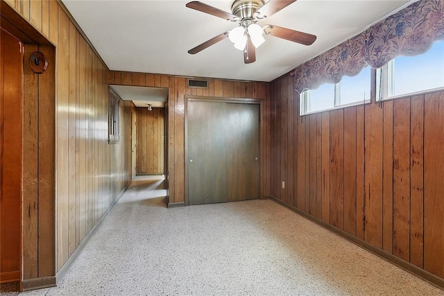 1017 Elmeer Ave, Metairie, LA 70005 - unfurnished bedroom featuring wooden walls, ceiling fan, baseboards, and a closet