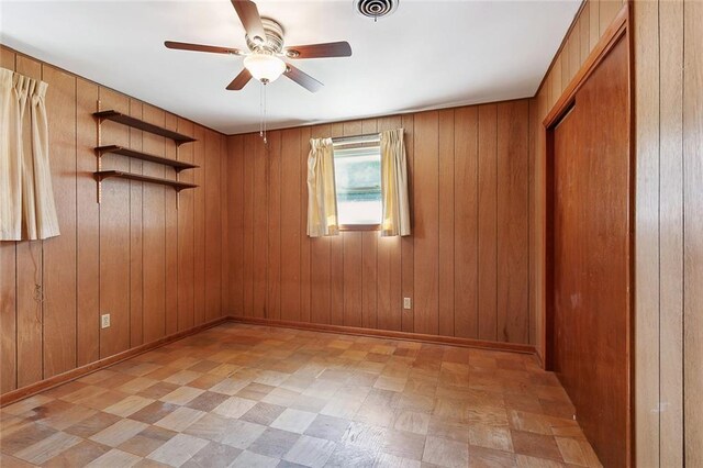 1017 Elmeer Ave, Metairie, LA 70005 - unfurnished bedroom with light floors, wood walls, and a ceiling fan