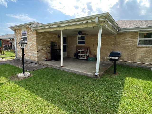 rear view of house with a patio, brick siding, and a yard