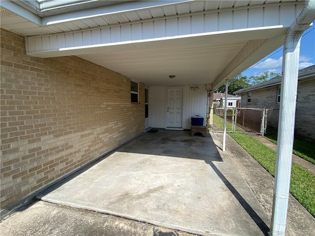 view of patio featuring a gate, fence, and a carport