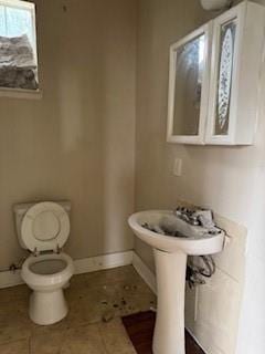 bathroom featuring tile patterned floors, toilet, and baseboards
