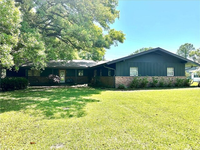 130 N Oak Ct, Luling, LA 70070 - ranch-style house featuring a front lawn, brick siding, and board and batten siding