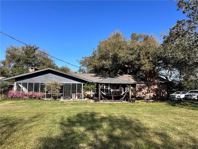 130 N Oak Ct, Luling, LA 70070 - back of property featuring a gazebo, a sunroom, and a lawn