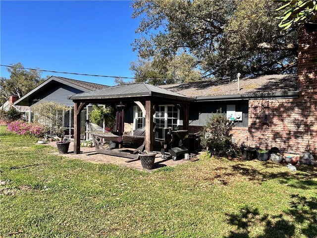 130 N Oak Ct, Luling, LA 70070 - rear view of property with a yard, brick siding, and a gazebo